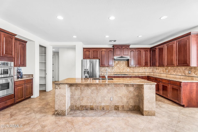 1755 E Tonto Dr, Chandler, AZ 85249 - kitchen featuring stainless steel appliances, under cabinet range hood, light stone counters, a kitchen island with sink, and recessed lighting