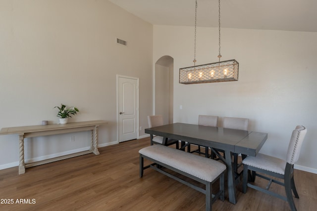 15128 W Melissa Ln, Surprise, AZ 85374 - dining area with arched walkways, wood finished floors, baseboards, and a towering ceiling
