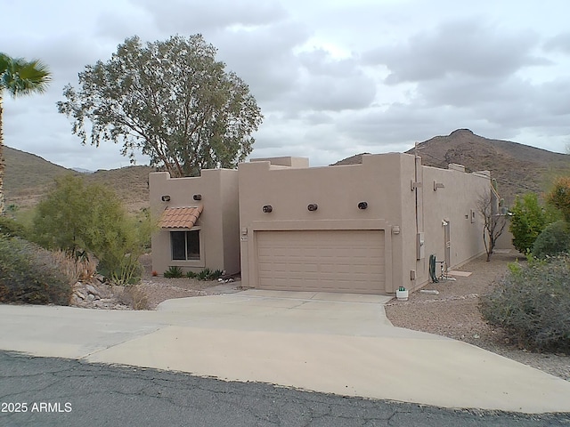 adobe home featuring a garage and a mountain view