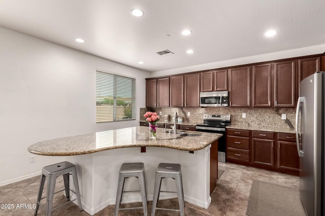 120 E Concorda Dr, Tempe, AZ 85282 - kitchen featuring visible vents, a sink, a kitchen breakfast bar, stainless steel appliances, and backsplash