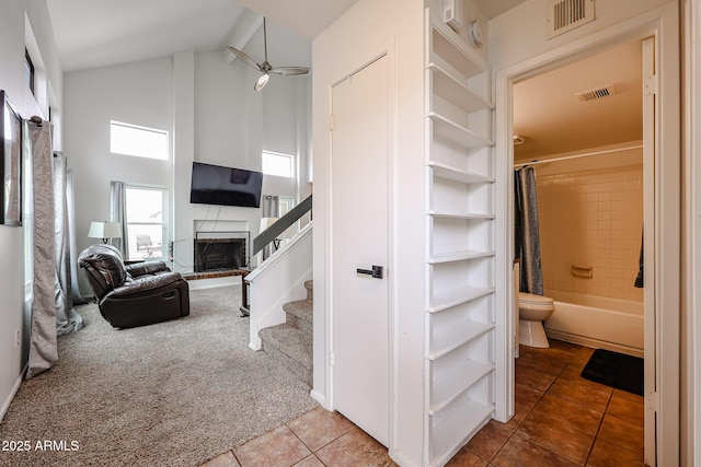 interior space featuring carpet flooring and high vaulted ceiling