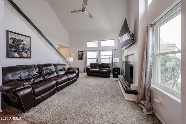 living room with ceiling fan, carpet, and high vaulted ceiling