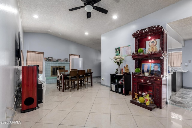 5432 W Sunnyside Dr, Glendale, AZ 85304 - tiled dining room featuring ceiling fan, a textured ceiling, vaulted ceiling, recessed lighting, and a fireplace with raised hearth