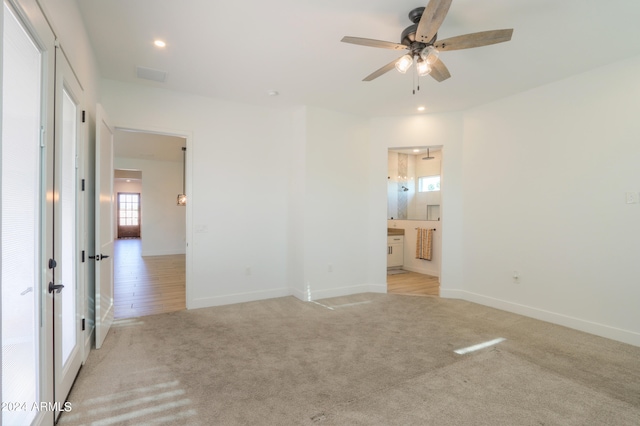 unfurnished bedroom with ceiling fan, light hardwood / wood-style floors, and ensuite bath