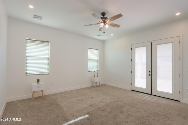 carpeted empty room featuring french doors and ceiling fan