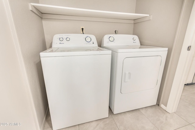 washroom with independent washer and dryer, light tile patterned flooring, and baseboards