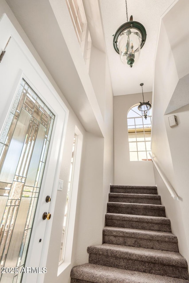 staircase with a chandelier