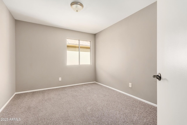 empty room featuring carpet flooring and baseboards