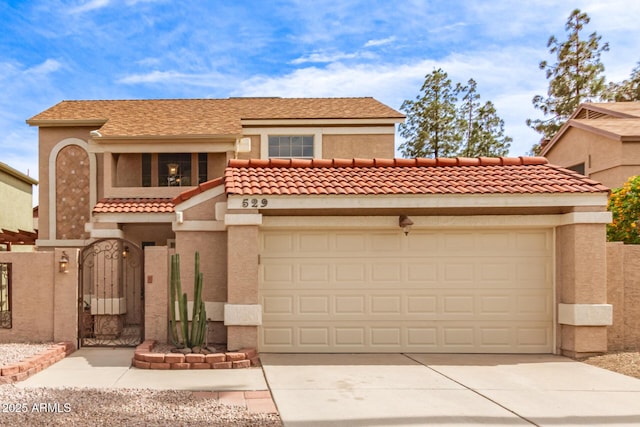 mediterranean / spanish-style home with concrete driveway, stucco siding, an attached garage, and a gate