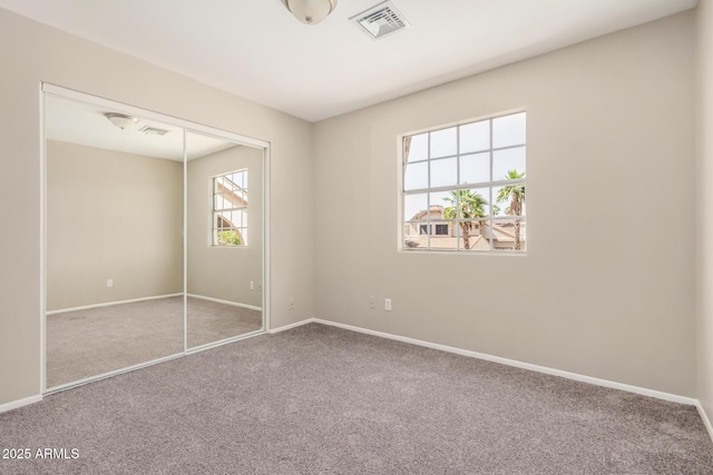 unfurnished bedroom with carpet flooring, baseboards, and a closet