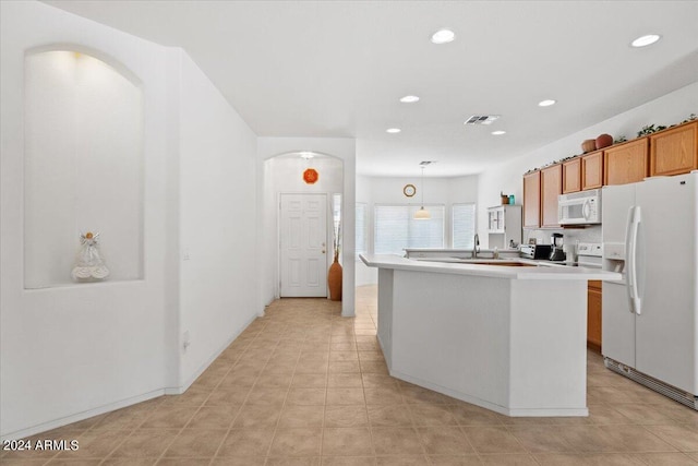 kitchen with hanging light fixtures, a center island with sink, white appliances, and light tile patterned flooring