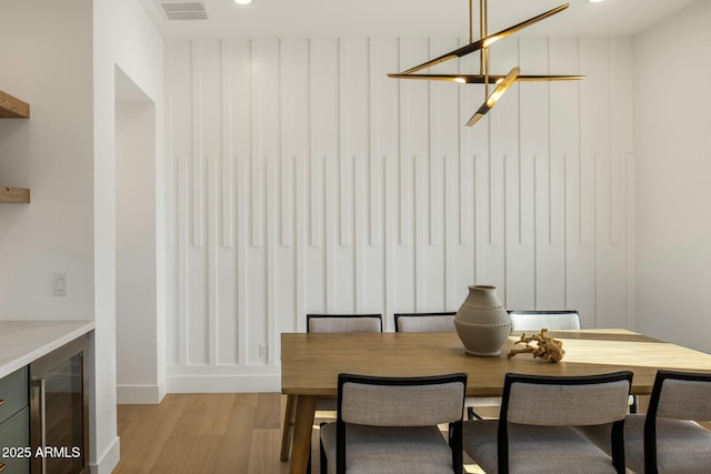 dining space featuring light wood-type flooring and wine cooler