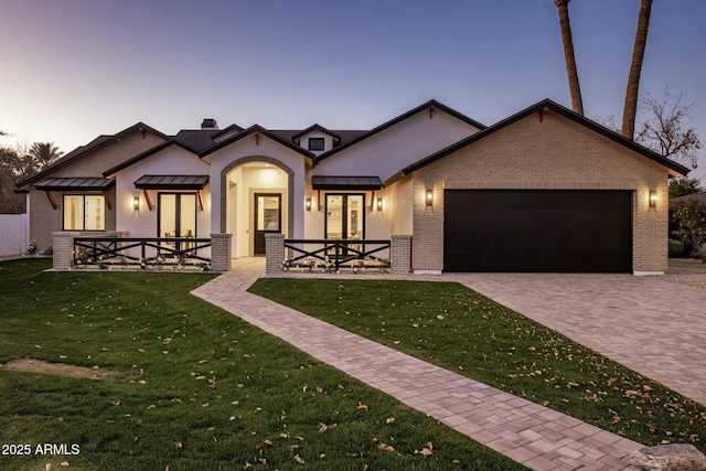 view of front of home featuring a garage and a lawn