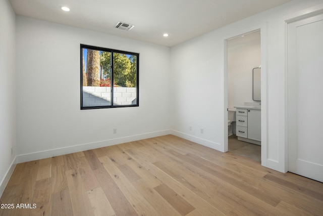 unfurnished bedroom featuring connected bathroom and light hardwood / wood-style flooring