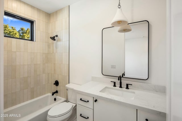 full bathroom featuring toilet, tiled shower / bath, and vanity