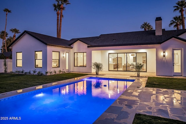 rear view of house with a lawn and a patio