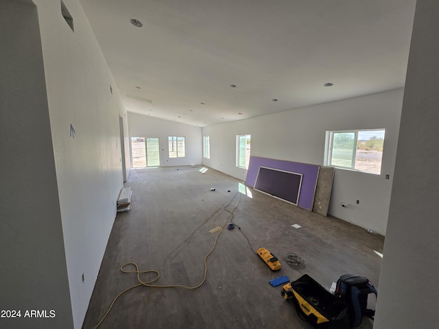 unfurnished living room featuring lofted ceiling and a healthy amount of sunlight