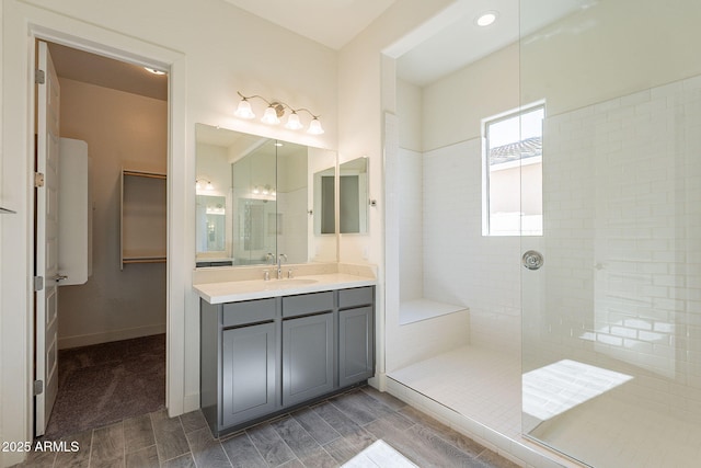 bathroom with vanity and a tile shower