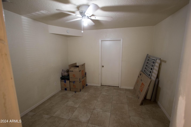 basement with a textured ceiling and ceiling fan