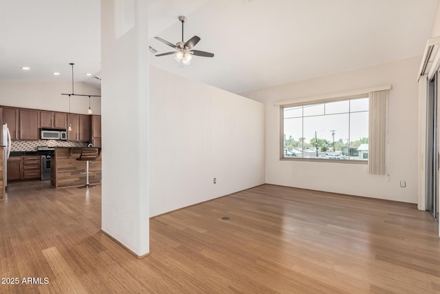 unfurnished living room with light wood-style floors, high vaulted ceiling, and a ceiling fan