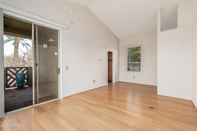 empty room featuring high vaulted ceiling and wood finished floors