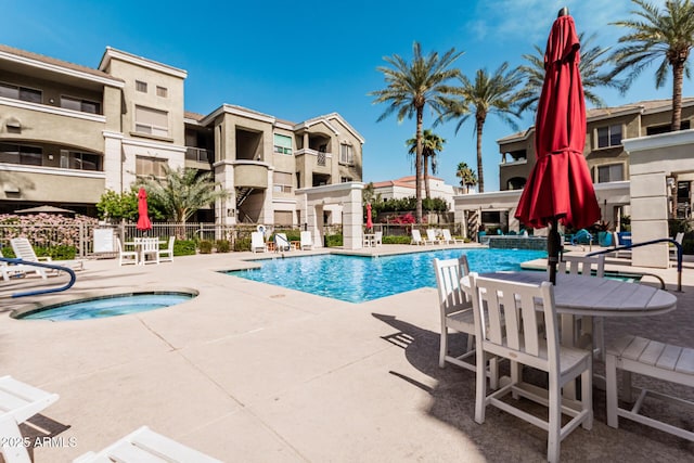 pool featuring a community hot tub, a patio area, and fence