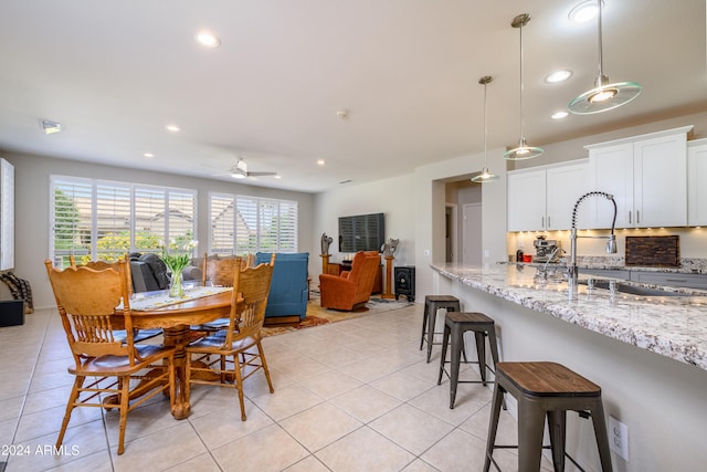 tiled dining space featuring ceiling fan