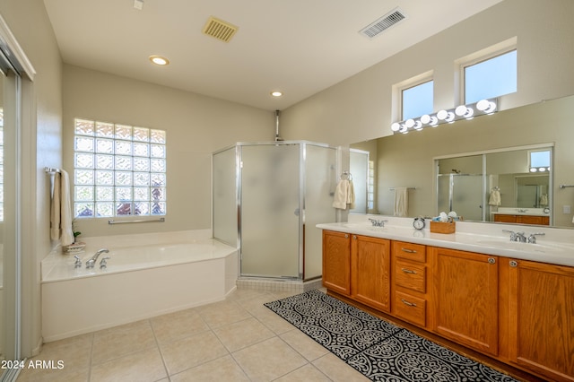 bathroom with vanity, tile patterned flooring, and plus walk in shower