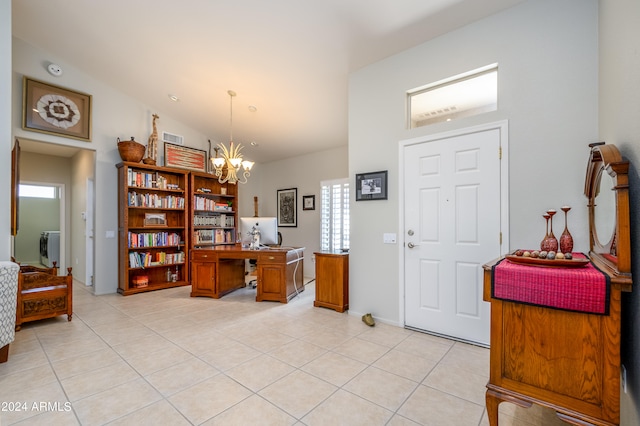 tiled foyer with vaulted ceiling and a chandelier