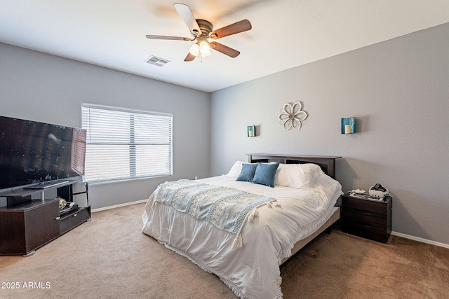 carpeted bedroom featuring a ceiling fan, visible vents, and baseboards