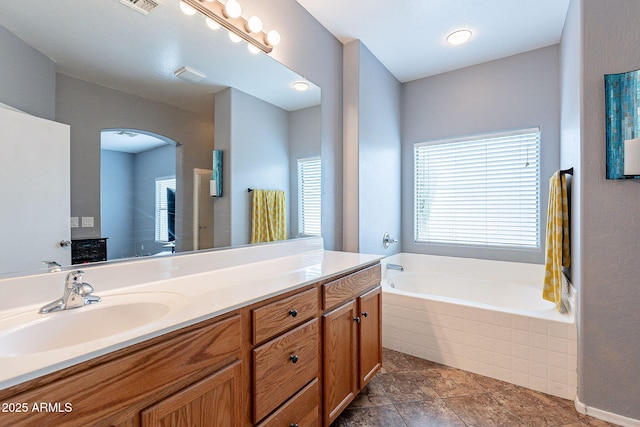 bathroom featuring a garden tub, visible vents, and vanity