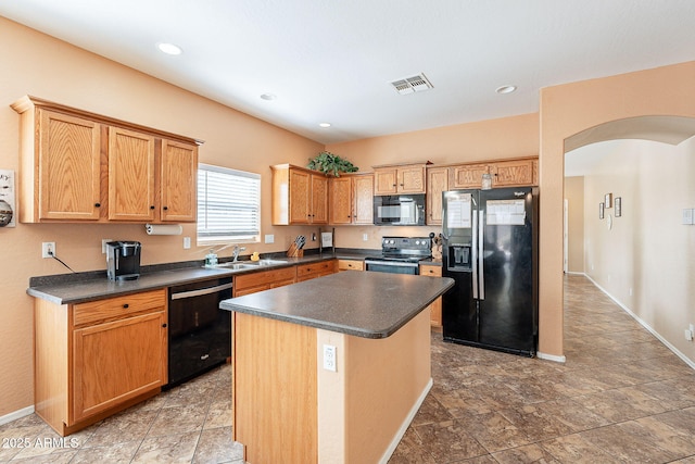 kitchen featuring visible vents, arched walkways, dark countertops, black appliances, and a sink