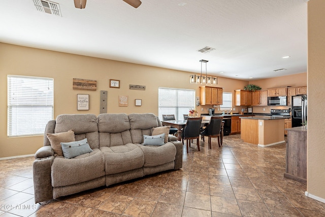 living area featuring tile patterned flooring, visible vents, and baseboards