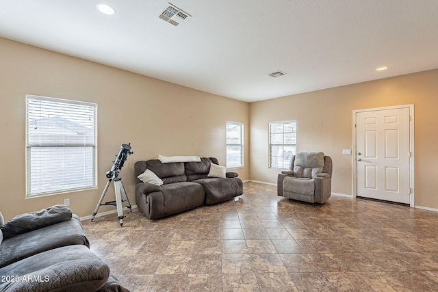 living area featuring baseboards, visible vents, and recessed lighting