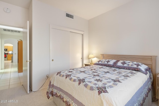 bedroom with light carpet and a closet