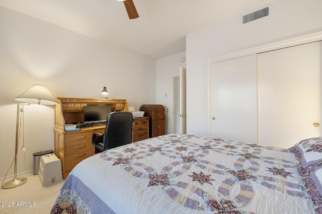 bedroom with ceiling fan, light colored carpet, and a closet