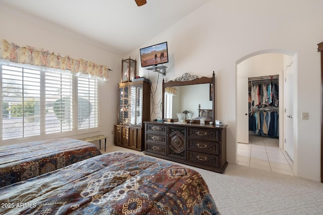 carpeted bedroom with lofted ceiling, a spacious closet, a closet, and ceiling fan