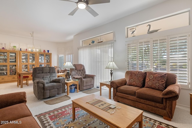 living room featuring light carpet, ceiling fan, and a healthy amount of sunlight