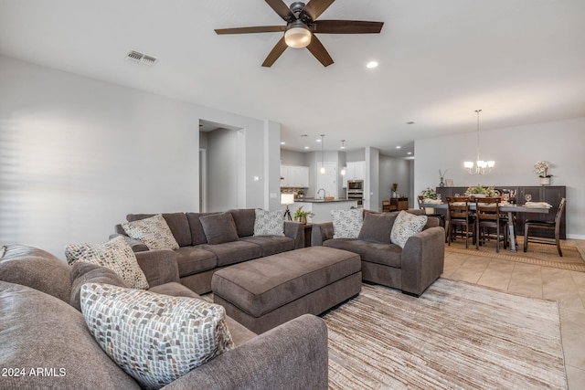 living room featuring ceiling fan with notable chandelier and light tile patterned floors