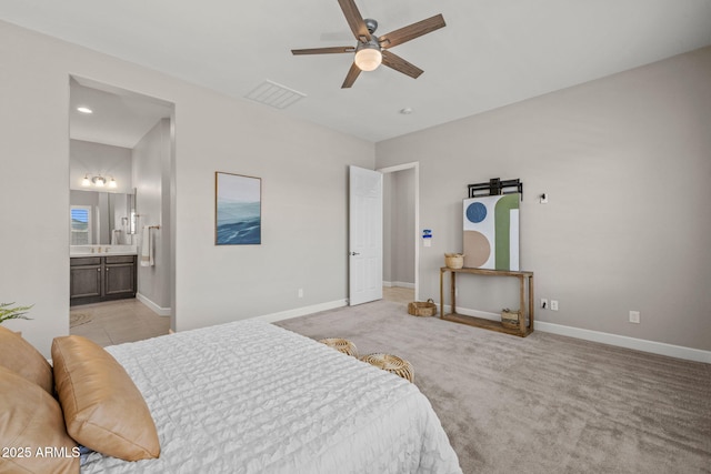 bedroom with light carpet, baseboards, visible vents, and ensuite bath