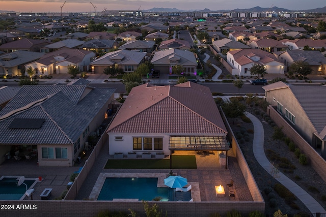 aerial view at dusk featuring a residential view and a mountain view