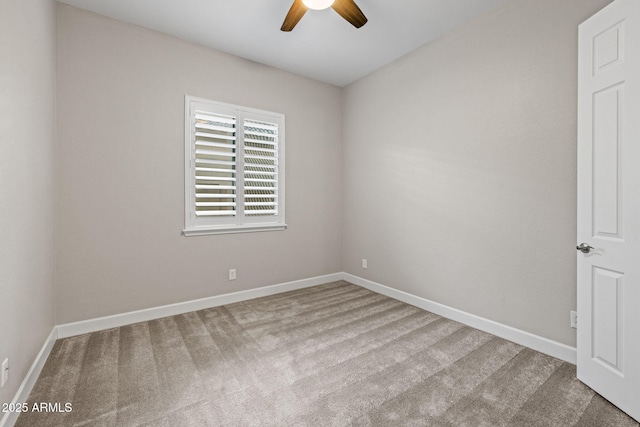 carpeted spare room featuring ceiling fan and baseboards