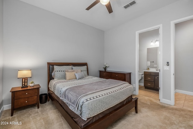 carpeted bedroom featuring ensuite bathroom, ceiling fan, and sink