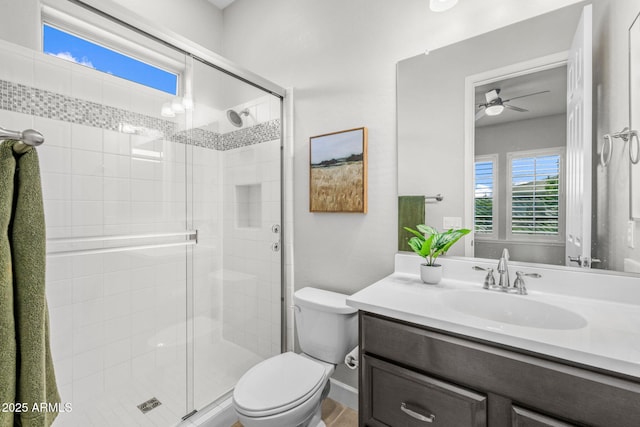 full bath with toilet, a shower stall, ceiling fan, and vanity