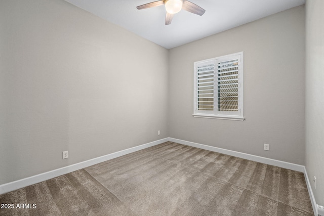carpeted spare room featuring baseboards and a ceiling fan