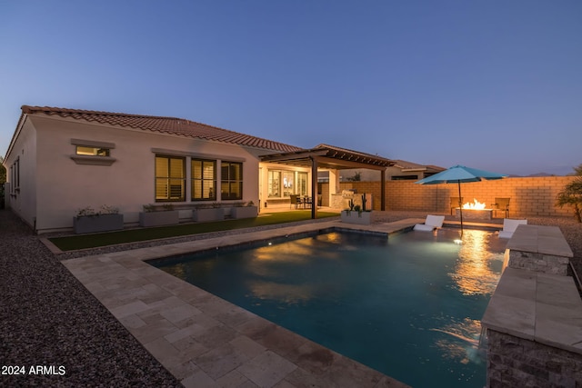 back of house with a fenced in pool, stucco siding, a patio area, a fenced backyard, and a tile roof