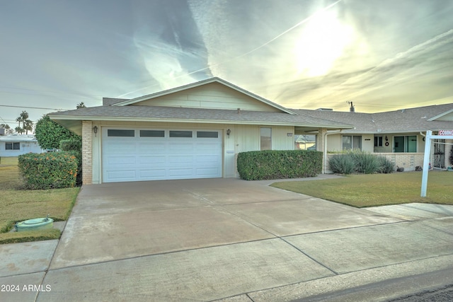 ranch-style house featuring a lawn and a garage