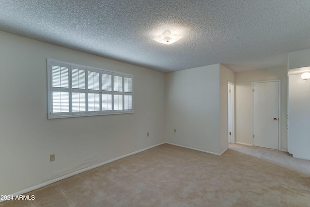 carpeted spare room featuring a textured ceiling