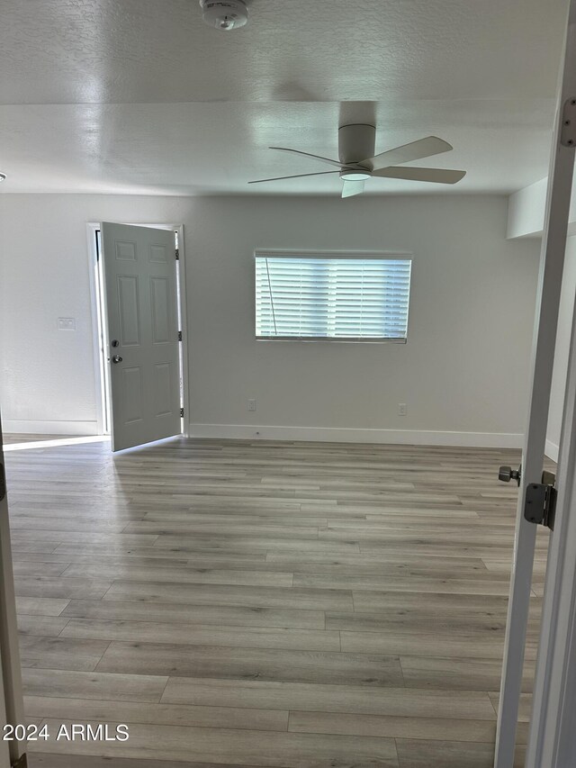 unfurnished room with a textured ceiling, ceiling fan, and hardwood / wood-style floors