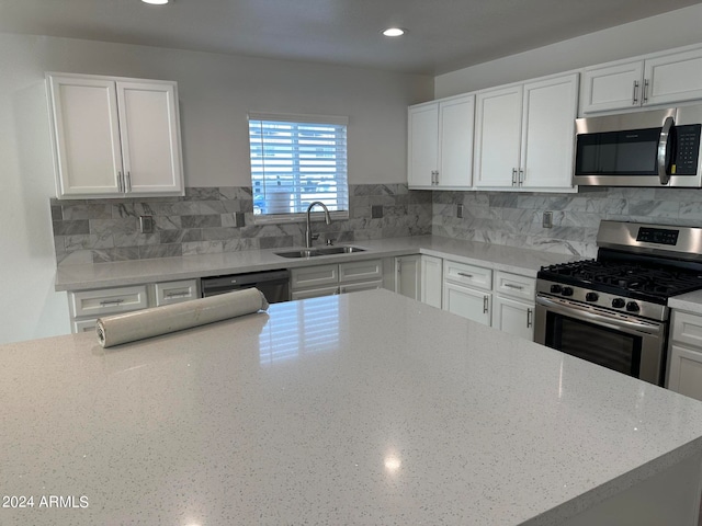 kitchen featuring sink, stainless steel appliances, white cabinets, and backsplash